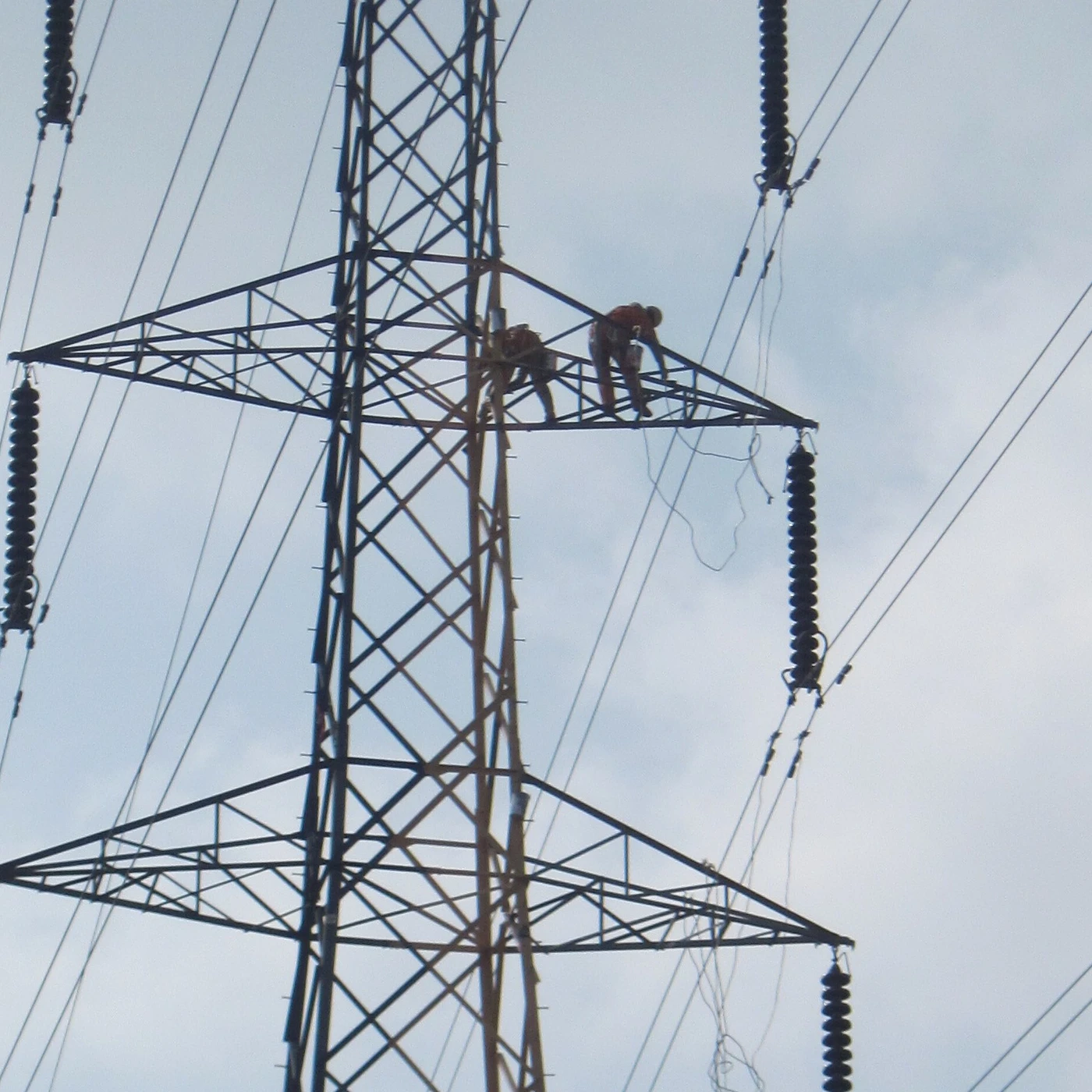 Peintres appliquant une peinture sur la structure métallique d’un pylône